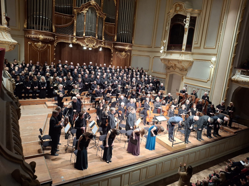 Orchester, Chor und Solisten verbeugen sich in RIchtung Publikum