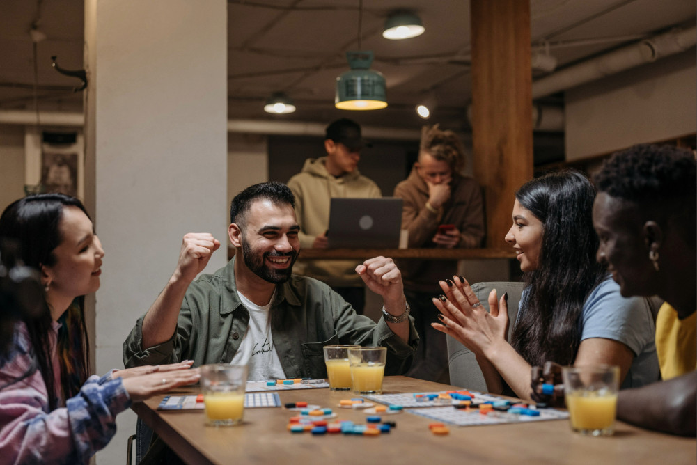 Gruppe von Freunden an einem fröhlichen Spieleabend an einem Tisch